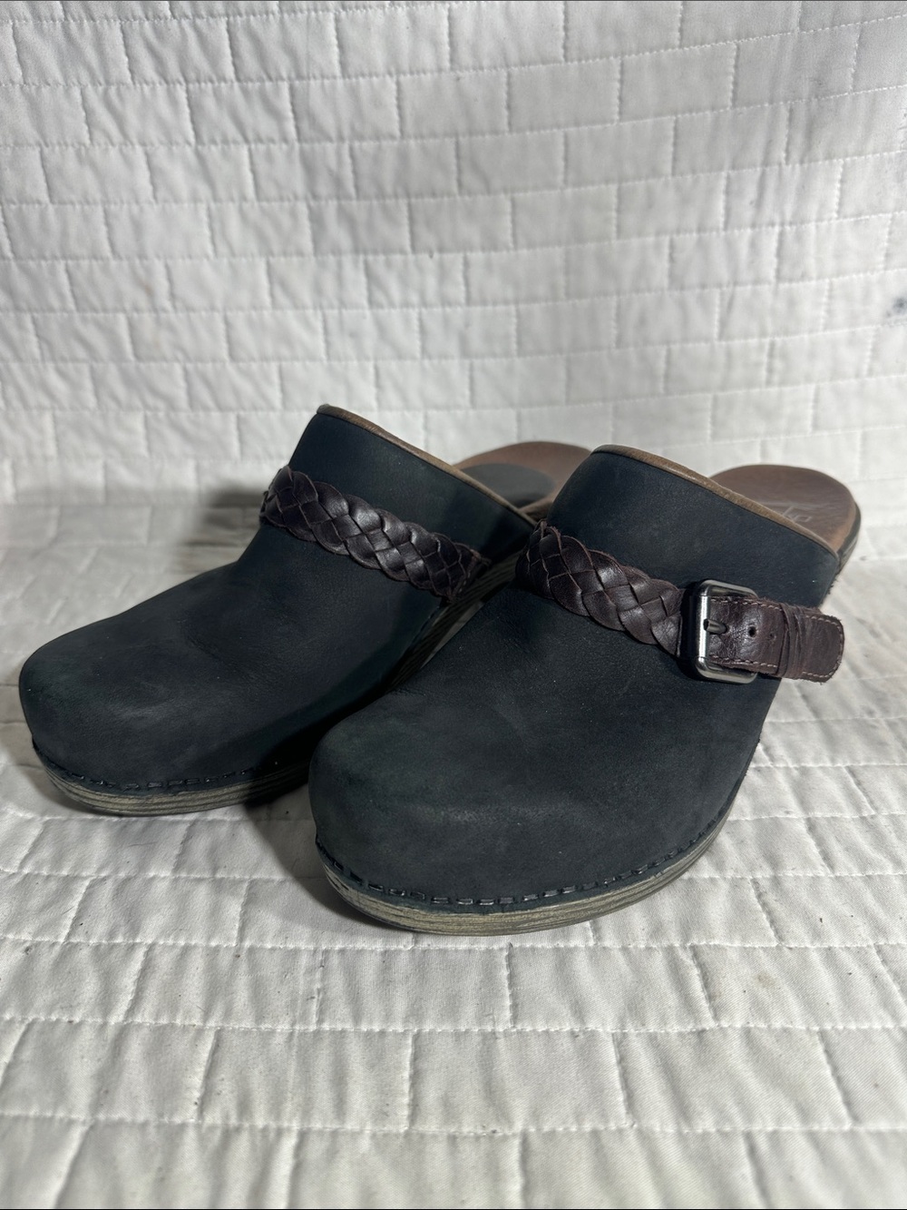 Dansko Melanie Clogs with a brown braided strap and buckle detail